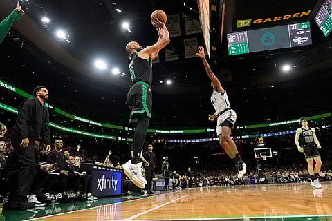 Boston Celtics guard Derrick White (9) soots over San Antonio Spurs forward Harrison Barnes (40) during the first half of an NBA basketball game in Boston.