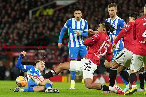 Brighton's Charalampos Kostoulas, left, and Manchester United's Leny Yoro fight for the ball during the FA Cup third round soccer match between Manchester United and Brighton in Manchester, England.