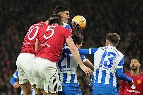Manchester United's Benjamin Sesko, left, scores during the FA Cup third round soccer match between Manchester United and Brighton in Manchester, England.