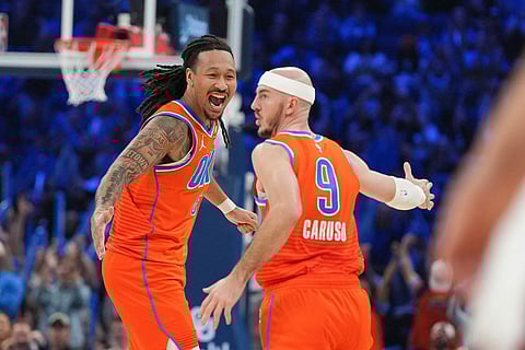 Oklahoma City Thunder forward Jaylin Williams, left, celebrates with guard Alex Caruso (9) during the second half of an NBA basketball game against the Miami Heat in Oklahoma City.
