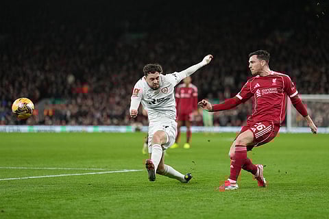 Liverpool's Andrew Robertson sends a cross by Barnsley's Corey O'Keeffe during the FA Cup third round soccer match between Liverpool and Barnsley in Liverpool, England.