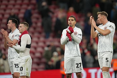 Barnsley players walk off the pitch after the FA Cup third round soccer match between Liverpool and Barnsley in Liverpool, England.