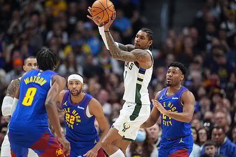 Milwaukee Bucks guard Kevin Porter Jr., third from left, passes the ball as Denver Nuggets guard Peyton Watson, left, center Zeke Nnaji and guard Jalen Pickett defend in the second half of an NBA basketball game in Denver.