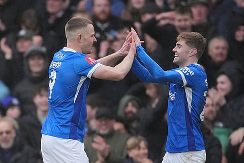 Portsmouth's Colby Bishop, left, and Jordan Williams celebrate after a goal during the FA Cup third round soccer match between Portsmouth and Arsenal in Portsmouth, England.