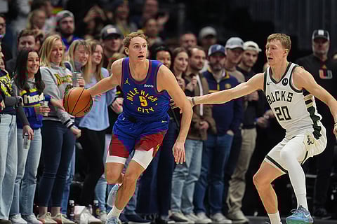 Denver Nuggets forward Hunter Tyson, left, drives past Milwaukee Bucks guard AJ Green, right, in the first half of an NBA basketball game in Denver.