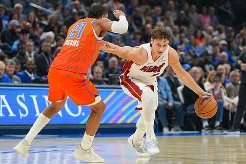 Miami Heat guard Pelle Larsson, right, drives past Oklahoma City Thunder guard Aaron Wiggins, left, during the first half of an NBA basketball game in Oklahoma City.