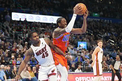 Oklahoma City Thunder guard Jalen Williams (8) grabs a rebound in front of Miami Heat guard Davion Mitchell (45) during the second half of an NBA basketball game in Oklahoma City.