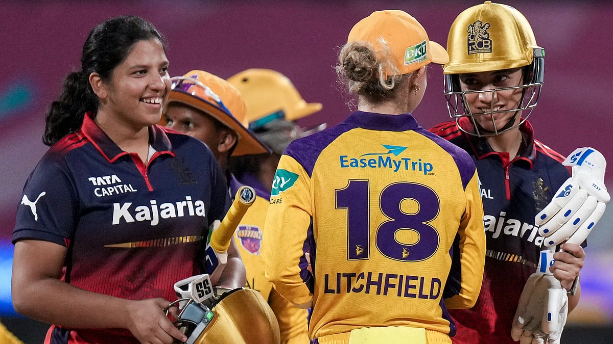 Royal Challengers Bengaluru's captain Smriti Mandhana, right, and Richa Ghosh, left, being congratulated by UP Warriorz's Phoebe Litchfield after winning the Women's Premier League. - PTI