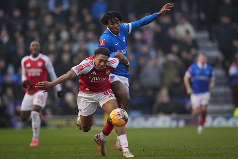 Arsenal's Myles Lewis-Skelly, left, and Portsmouth's Franco Umeh-Chibueze fight for the ball during the FA Cup third round soccer match between Portsmouth and Arsenal in Portsmouth, England.