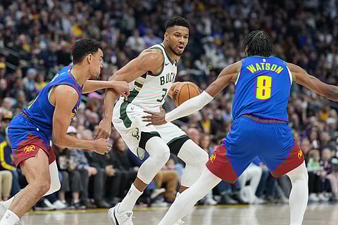 Milwaukee Bucks forward Giannis Antetokounmpo, center, drives to the net between Denver Nuggets forward Spencer Jones, left, and guard Peyton Watson in the first half of an NBA basketball game in Denver.