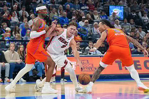 Miami Heat guard Pelle Larsson, middle, drives past Oklahoma City Thunder guard Shai Gilgeous-Alexander, left, and forward Jaylin Williams during the first half of an NBA basketball game in Oklahoma City.
