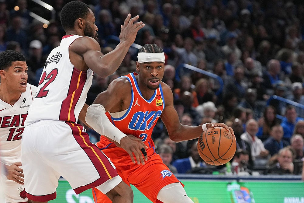 Oklahoma City Thunder guard Shai Gilgeous-Alexander, right, pushes past Miami Heat forward Andrew Wiggins during the second half of an NBA basketball game in Oklahoma City. - | Photo: AP/Kyle Phillips