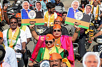 | Photo: PTI : A supporter holds placards during a roadshow led by Maharashtra Chief Minister Devendra Fadnavis, unseen, on the last day of campaigning for the civic elections, in Nagpur.