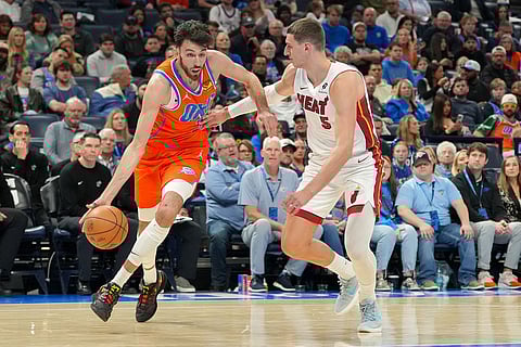 Oklahoma City Thunder center Chet Holmgren, left, drives past Miami Heat forward Nikola Jovic, right, during the second half of an NBA basketball game in Oklahoma City.