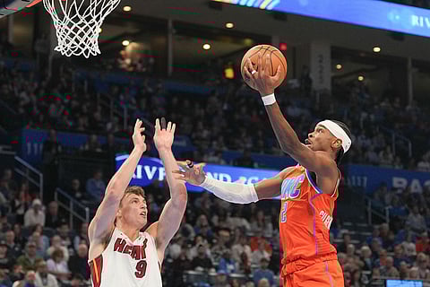 Oklahoma City Thunder guard Shai Gilgeous-Alexander, right, shoots over Miami Heat guard Pelle Larsson during the second half of an NBA basketball game in Oklahoma City.