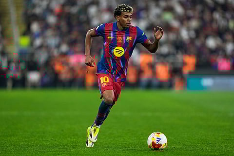 Barcelona's Lamine Yamal runs with the ball during the Spanish Super Cup final soccer match against Real Madrid at King Abdullah Sports City Stadium in Jeddah, Saudi Arabia.
