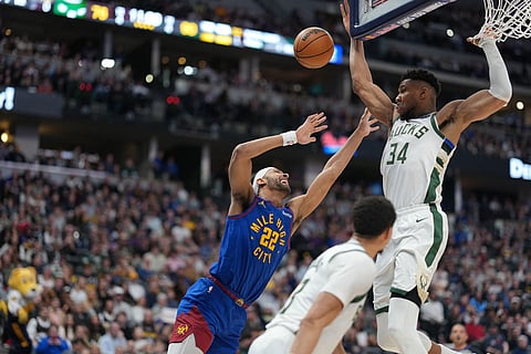 Denver Nuggets center Zeke Nnaji, left, has his shot blocked by Milwaukee Bucks forward Giannis Antetokounmpo, right, as guard Ryan Rollins follows the play in the second half of an NBA basketball game  in Denver.