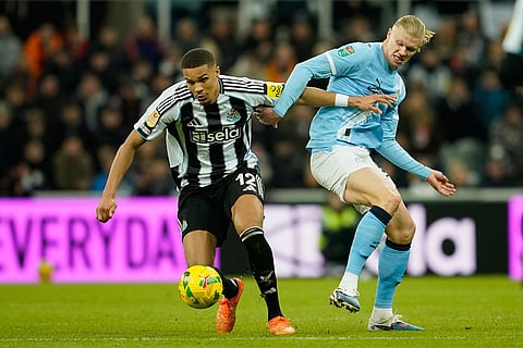 Newcastle's Malick Thiaw, left, fights for the ball with Manchester City's Erling Haaland during the English League Cup semifinal first leg soccer match between Newcastle and Manchester City in Newcastle, England.