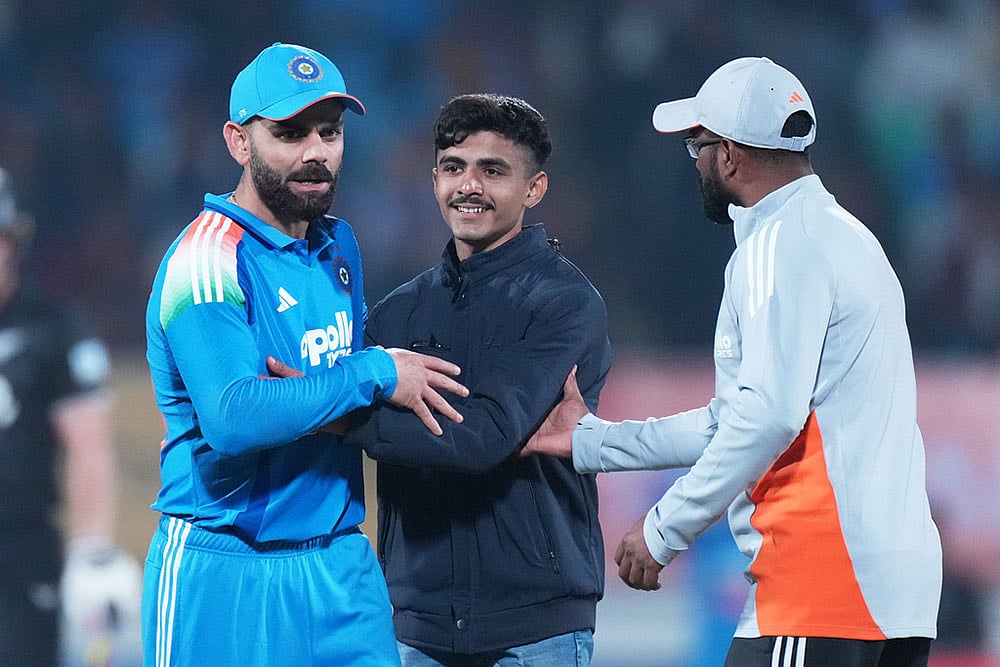 An Indian fan hugs Indias Virat Kohli 