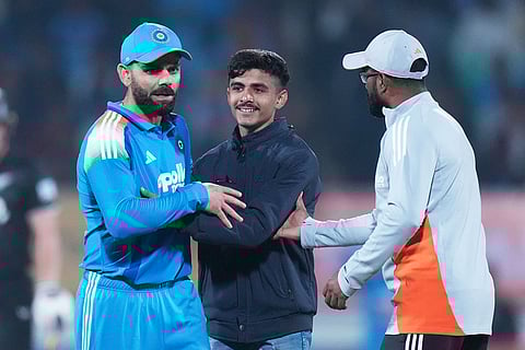 An Indian fan hugs India's Virat Kohli during the second One Day International cricket match between India and New Zealand in Rajkot, India.