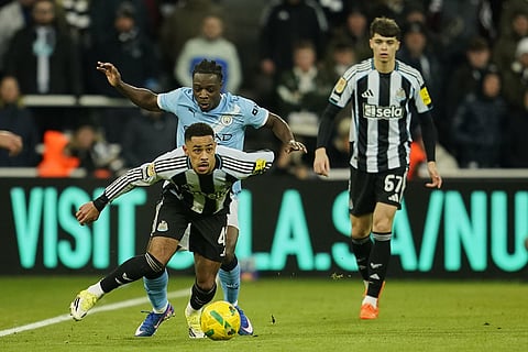 Newcastle's Jacob Ramsey, foreground, is challenged by Manchester City's Jeremy Doku during the English League Cup semifinal first leg soccer match between Newcastle and Manchester City in Newcastle, England.