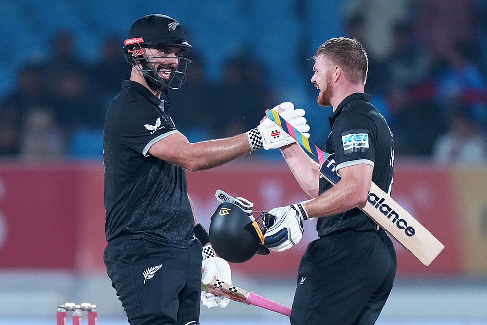 Photo: AP/Ajit Solanki : New Zealand's Daryl Mitchell, left, and New Zealand's Glenn Phillips celebrate their win during the second One Day International cricket match between India and New Zealand in Rajkot, India.