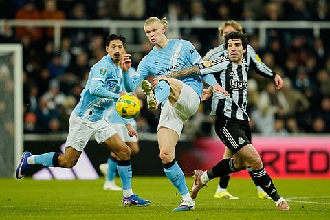 Manchester City's Erling Haaland, left, is challenged by Newcastle's Sandro Tonali during the English League Cup semifinal first leg soccer match between Newcastle and Manchester City in Newcastle, England.