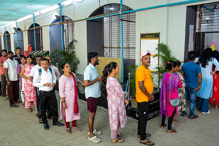 People wait in a queue to cast votes at a polling station during the municipal corporation elections in Thane, Maharashtra. - PTI