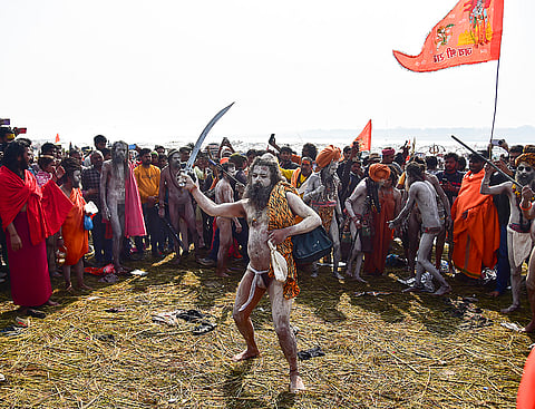 A Naga sadhu of 'Shri Panch Dashnam Avahan Akhara' displays skills with a sword during the Magh Mela festival at the Sangam, in Prayagraj.