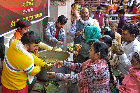 People take ‘Khichdi’, rice and lentil porridge, at the Vindhyavasini Temple in Mirzapur. 