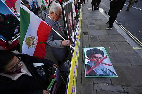 Protesters hold up placards and flag as they demonstrate in support of anti-government protests in Iran, outside Downing Street, in London.