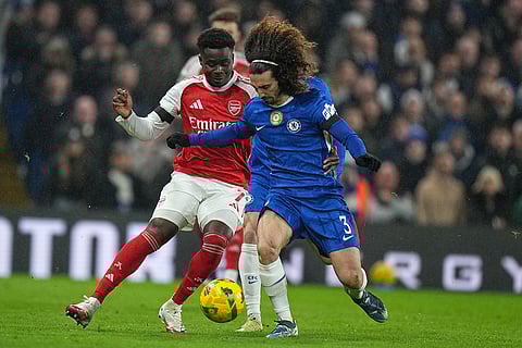 Arsenal's Bukayo Saka, left, vies for the ball with Chelsea's Marc Cucurella during the English League Cup semifinal first leg soccer match between Chelsea and Arsenal in London.