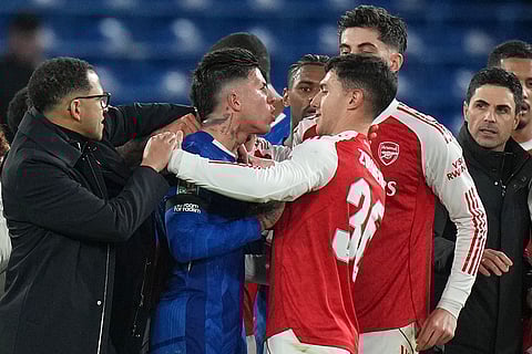 Chelsea's head coach Liam Rosenior, left, tries to break up an altercation between Chelsea's Enzo Fernandez, center, and Arsenal's Martin Zubimendi as Arsenal's manager Mikel Arteta watches at the end of the English League Cup semifinal first leg soccer match between Chelsea and Arsenal in London.