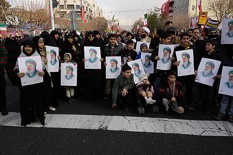People hold posters of the Iranian Supreme Leader Ayatollah Ali Khamenei during a funeral ceremony for a group of security forces, who were killed during anti-government protests, in Tehran, Iran.