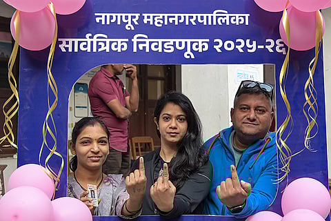 People show their ink marked fingers after casting votes at a polling station during the Nagpur Municipal Corporation (NMC) elections, in Nagpur, Maharashtra.