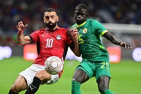 Egypt's Mohamed Salah, left, is challenged by Senegal's El Hadji Malick Diouf during the Africa Cup of Nations semifinal soccer match between Senegal and Egypt, in Tangier, Morocco.