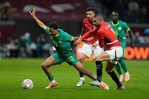 Senegal's Iliman Ndiaye, left, is challenged by Egypt's Trezeguet and Egypt's Ramy Rabiaa during the Africa Cup of Nations semifinal soccer match between Senegal and Egypt, in Tangier, Morocco.