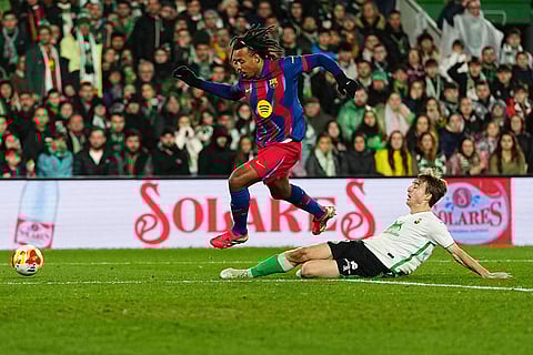 Barcelona's Jules Kounde, left, fights for the ball with Rancing Santander's Javier Castro during the Copa del Rey round of 16 soccer match between Racing Santander and Barcelona, in Santander, Spain.