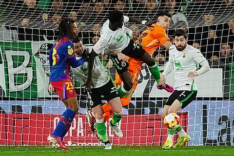 Barcelona's goalkeeper Joan Garcia, second right, clears a ball during the Copa del Rey round of 16 soccer match between Racing Santander and Barcelona, in Santander, Spain.