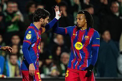 Barcelona's Ferran Torres, left, celebrates with his teammate Barcelona's Jules Kounde after scoring the opening goal during the Copa del Rey round of 16 soccer match between Racing Santander and Barcelona, in Santander, Spain.