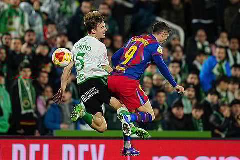 Rancing Santander's Javier Castro, left, fights for the ball with Barcelona's Robert Lewandowski during the Copa del Rey round of 16 soccer match between Racing Santander and Barcelona, in Santander, Spain.