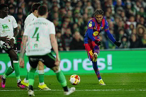Barcelona's Lamine Yamal, right, tries a shot during the Copa del Rey round of 16 soccer match between Racing Santander and Barcelona, in Santander, Spain.
