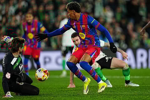 Barcelona's Lamine Yamal, right, tries a shot next to Rancing Santander's goalkeeper Jokin Ezkieta during the Copa del Rey round of 16 soccer match between Racing Santander and Barcelona, in Santander, Spain.
