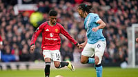(AP Photo/Dave Thompson) : Manchester United's Amad Diallo, left, and Manchester City's Nathan Ake in action during the English Premier League soccer match between Manchester United and Manchester City in Manchester, England, Saturday, Jan. 17, 2026.