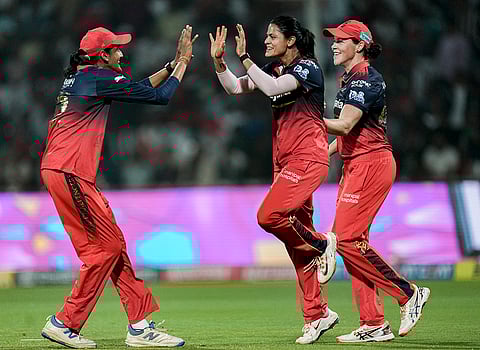 Royal Challengers Bengaluru's Radha Yadav, center, Grace Harris, right, and Gautami Naik during the Women's Premier League (WPL) T20 cricket match between Royal Challengers Bengaluru and Gujarat Giants, at the DY Patil Stadium, in Navi Mumbai.