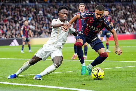 Levantes' Jeremy Toljan, right, and Real Madrid's Vinicius Junior fight for the ball during the Spanish La Liga soccer match between Real Madrid and Levante in Madrid, Spain.