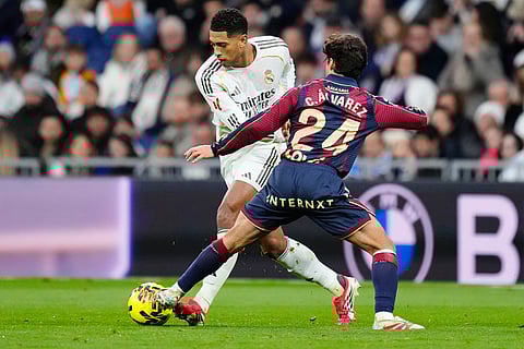 Levantes' Carlos Alvarez tackles Real Madrid's Jude Bellingham is challenged by during the Spanish La Liga soccer match between Real Madrid and Levante in Madrid, Spain.