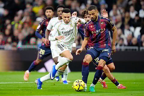 Levantes' Jeremy Toljan, right, fights for the ball with Real Madrid's Kylian Mbappe during the Spanish La Liga soccer match between Real Madrid and Levante in Madrid, Spain.