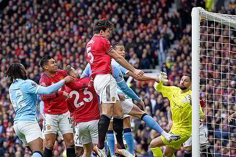 Manchester United's Harry Maguire, centre, makes an attempt to score during the English Premier League soccer match between Manchester United and Manchester City in Manchester, England.