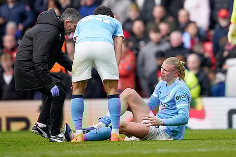 Manchester City's Erling Haaland receives medical attention during the English Premier League soccer match between Manchester United and Manchester City in Manchester, England.